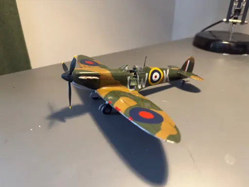 1:48 tamiya spitfire in RAF Green and brown on a grey desk. The camo pattern matches Battle of Britain era