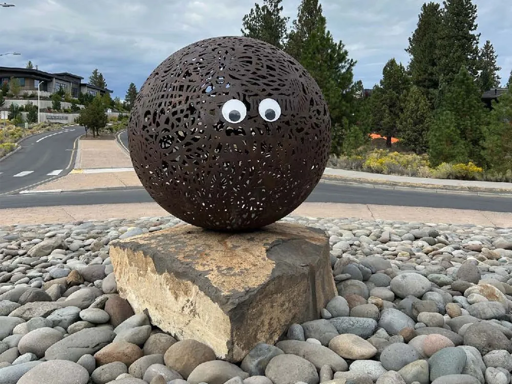 Artist Brandon Zebold's Orb I, a large spherical sculpture, with googly eyes stuck to it.