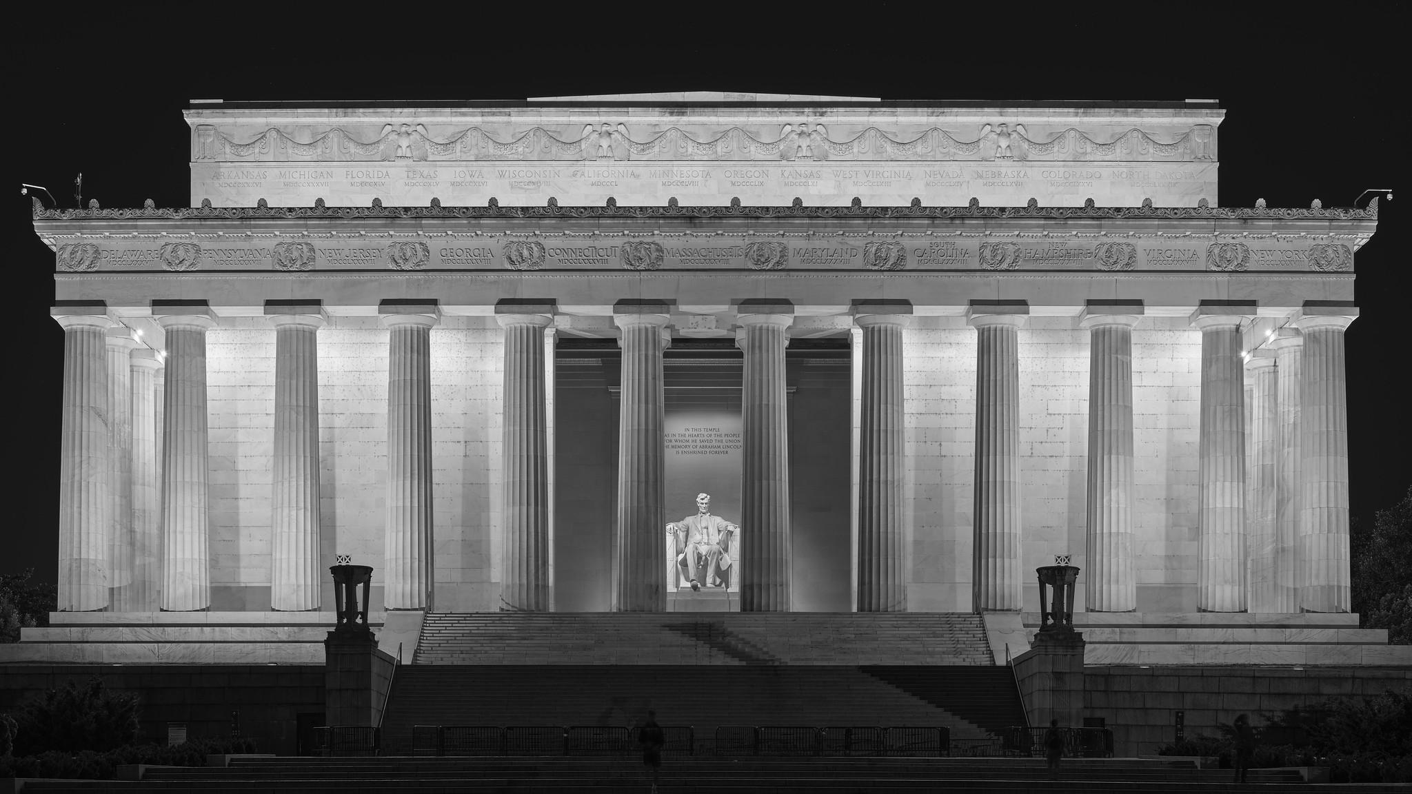 Front of the Lincoln Memorial at night, with columns and statue illuminated by floodlights.