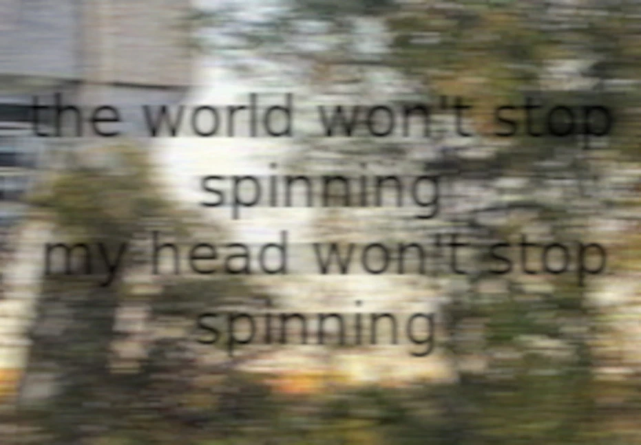 motion blurred image of trees and part of a bridge with blurry black text reading "the world won't stop spinning my head won't stop spinning"